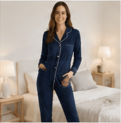 Femme portant une combinaison pyjama bleu marine dans une chambre lumineuse et élégante.